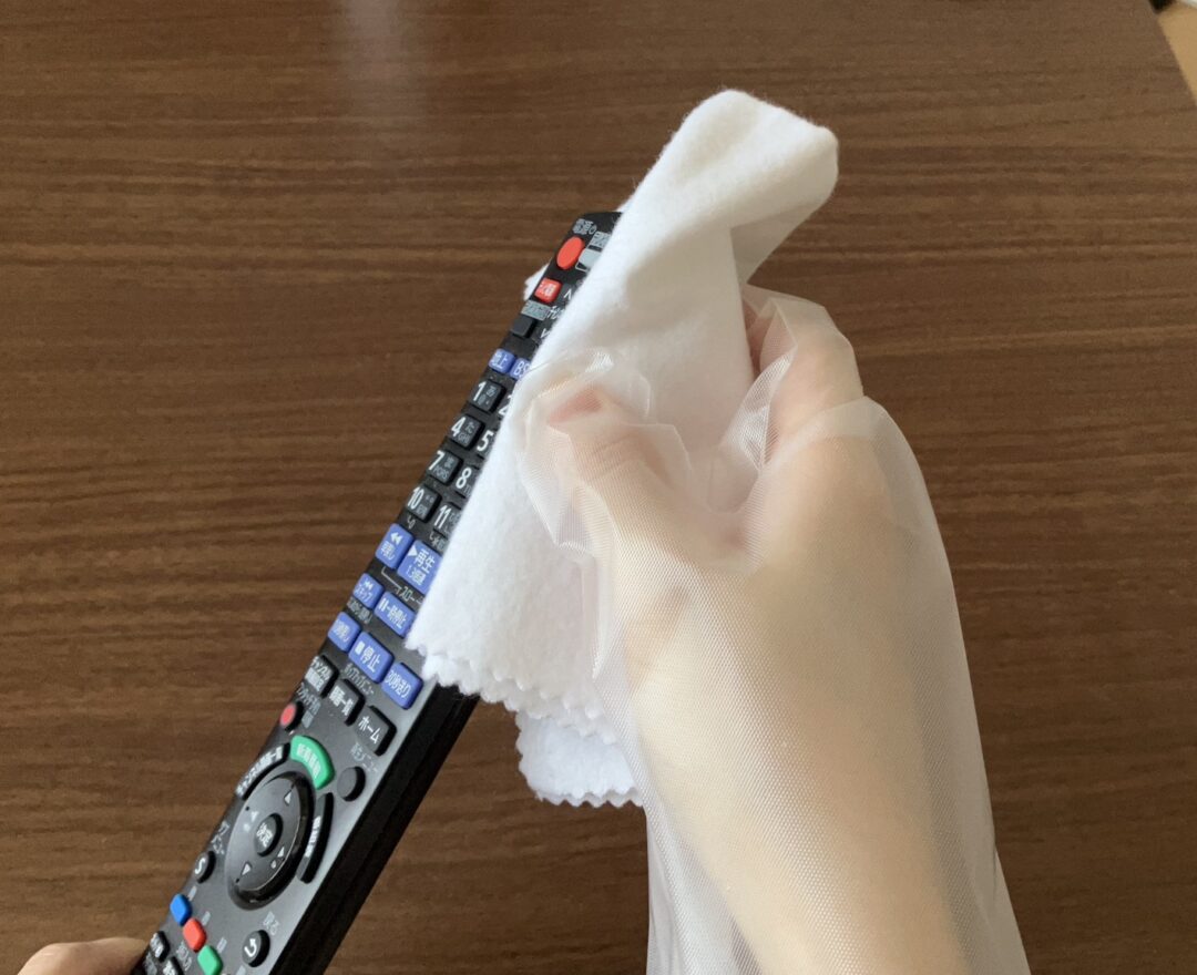 柔らかい布でリモコンを拭く様子