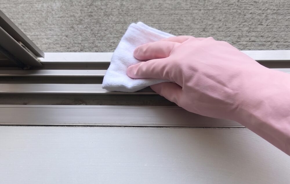 アルミサッシを水拭きして仕上げる様子